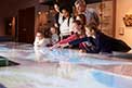 Pupils On School Field Trip To Museum Looking At Map