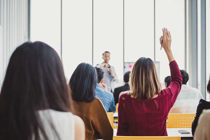 Back view business woman raising hand for asking speaker