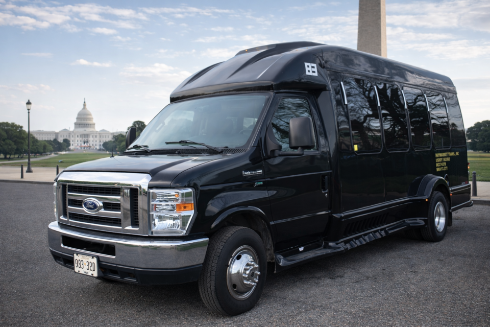 Black Ford E-Series shuttle bus providing professional group transportation in Washington DC near the U.S. Capitol and Washington Monument.